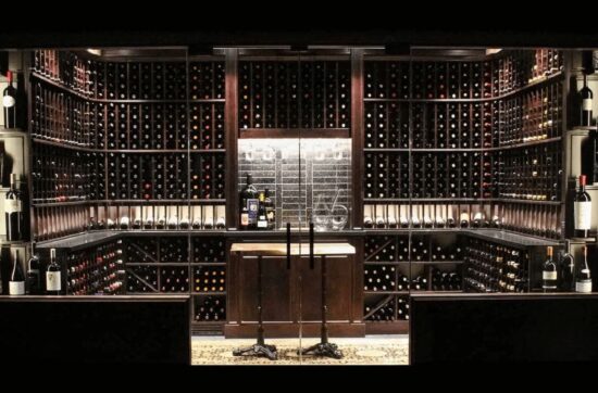 traditional wine cellar design with glass door and wooden racks by Genuwine Cellars