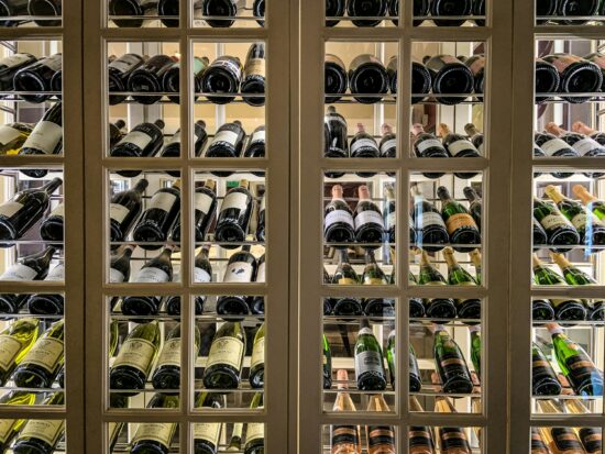 Custom wooden wine cellar with glass-front wine storage racks and bottle display