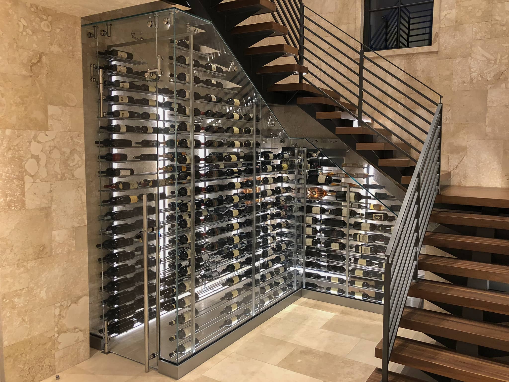 glass-enclosed Wine Room underneath a floating staircase
